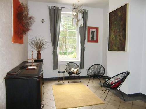 sala de estar con sillas, mesa y ventana en Villa Ambrosian (Haupthaus), en Trzebież