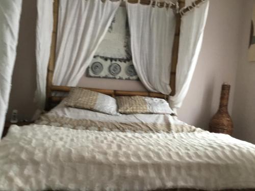 - une chambre avec un lit doté de draps et de rideaux blancs dans l'établissement Villa moderne piscine privée calme soleil près de Nîmes, à Clarensac