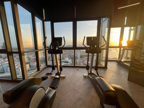 a gym with several treadmills in a building with windows at The Edge Central Pattaya Seaview in Pattaya
