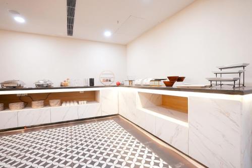 a kitchen with white cabinets and a black and white tile floor at Hotel Limon & Banquet Sector 29, Gurgaon in Gurgaon