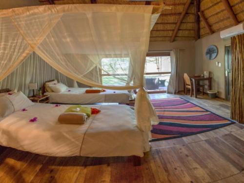 Kayova River Lodge في Ndiyona: غرفة نوم بسريرين ونافذة كبيرة