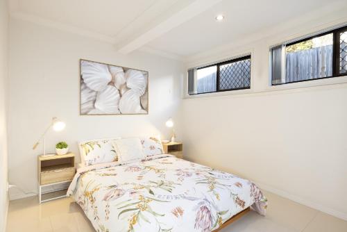 a bedroom with a bed and two windows at Super Host! 2 bedrooms, Restaurants & Train in Brisbane