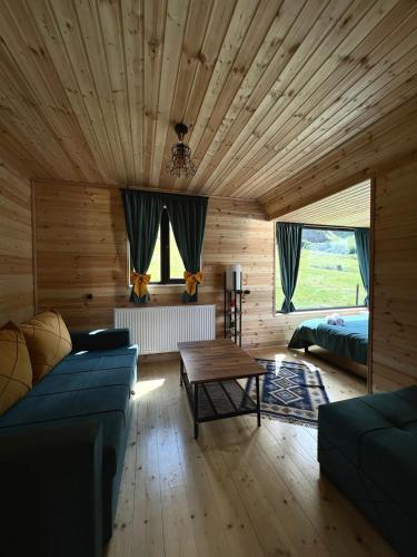 a living room with a blue couch and a wooden ceiling at Kazbegi Inn Cottages in Stepantsminda