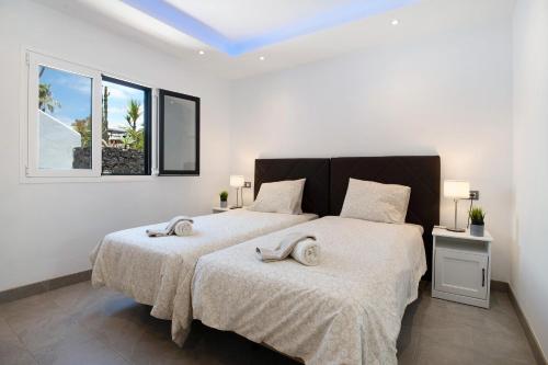 two beds in a bedroom with two towels on them at Tranquilidad 300m to beach freewifi in Puerto del Carmen