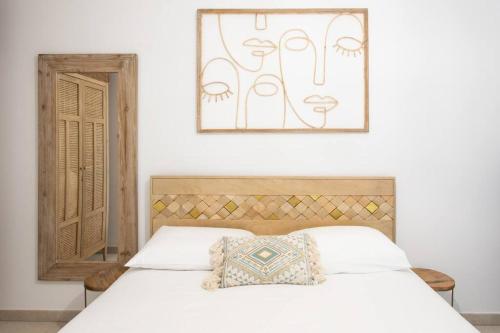 - une chambre avec un lit blanc et une photo sur le mur dans l'établissement A12 - 1 BDR Centre Train Station 5 min Sea - AC, Parking & Terrace, à Antibes