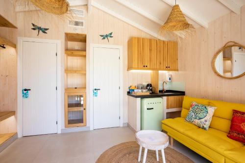 a living room with a yellow couch and a kitchen at Dunas Luxury Beach Resort Tarifa in Tarifa