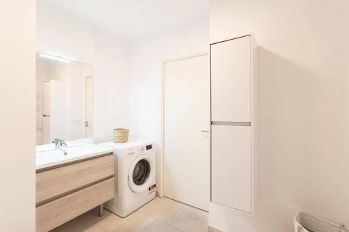 une salle de bain blanche avec une machine à laver et un lavabo dans l'établissement A12 - 1 BDR Centre Train Station 5 min Sea - AC, Parking & Terrace, à Antibes