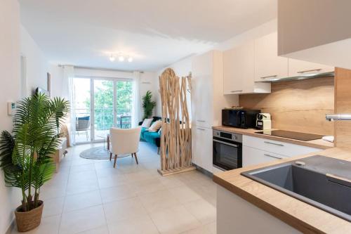 une cuisine avec un évier et un salon dans l'établissement A12 - 1 BDR Centre Train Station 5 min Sea - AC, Parking & Terrace, à Antibes