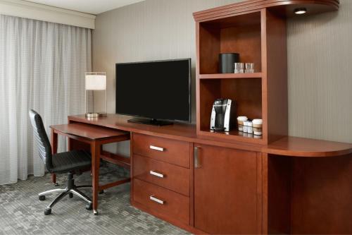 a hotel room with a desk with a television on it at Courtyard by Marriott Ottawa Downtown in Ottawa
