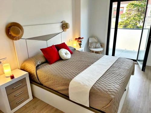 a bedroom with a large bed with red pillows at Holibai, Bon Xeito, Moderno y Cómodo Apartamento in Baiona