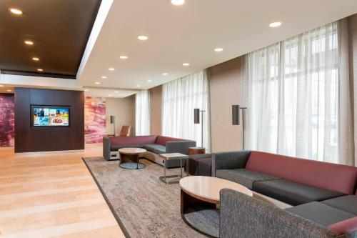 a lobby with couches and tables and a tv at Courtyard by Marriott Louisville Downtown in Louisville