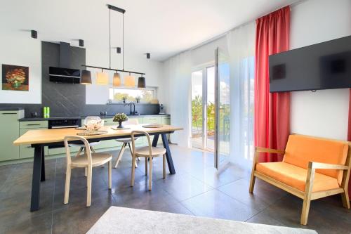 a kitchen and dining room with a table and chairs at Apartment NeWA in Gąski