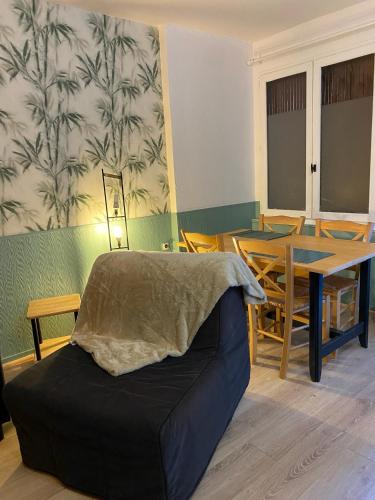 un salon avec un canapé et une table dans l'établissement Le nid vert, à Eaux-Bonnes