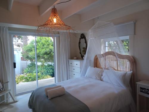 ein Schlafzimmer mit einem Bett und einem großen Fenster in der Unterkunft Klein Paradys in Kleinmond
