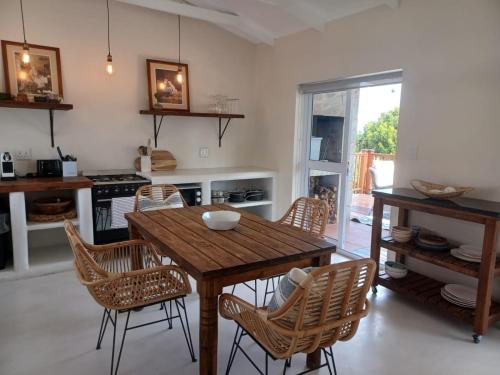 a kitchen with a wooden table and chairs at Klein Paradys in Kleinmond