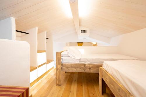 a room with two beds and a wooden ceiling at Dunas Luxury Beach Resort Tarifa in Tarifa