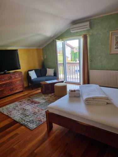 a bedroom with a bed and a tv and a couch at Antik in Strmec Samoborski