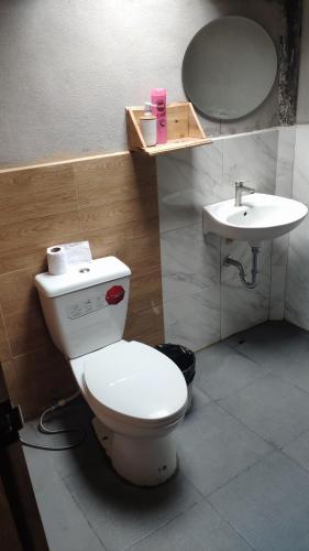 a bathroom with a toilet and a sink at PeaMoo Homestay in Chom Thong
