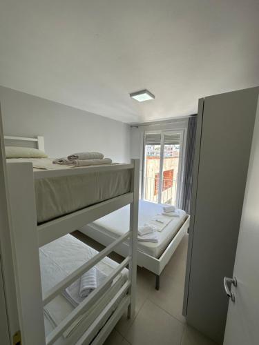um pequeno quarto com 2 beliches e uma janela em Merville Apartment 6 em Durrës