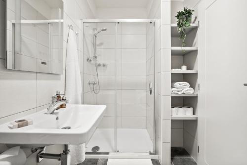 a white bathroom with a sink and a shower at Enjoy Downtown Boutique Apartments #13 by Goodnite cz in Brno