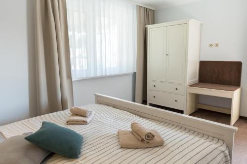 a bedroom with a bed with two pillows and a chair at Villa-Meehr in Bantikow