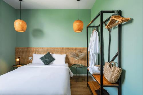 a bedroom with a bed and two pendant lights at Leaf Hotel Phu Quoc in Phu Quoc