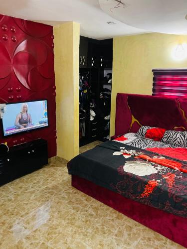 a bedroom with a bed and a flat screen tv at Dsmarts apartments in Benin City