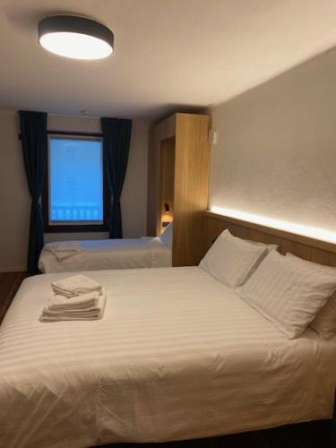 a hotel room with a bed with towels on it at Hotel SALEI in Ghigo