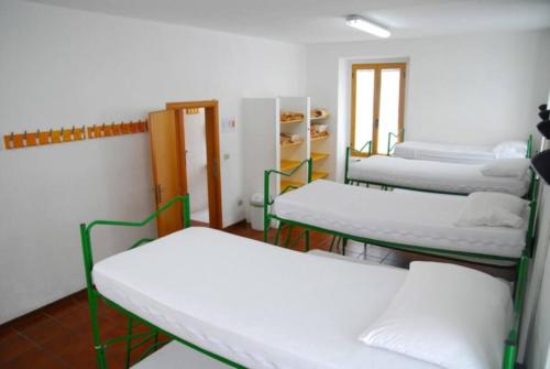 een kamer met 3 bedden en een raam bij Ostello della gioventù Intera struttura in Lama dei Peligni