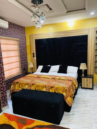 - une chambre avec un grand lit et une grande tête de lit dans l'établissement Dsmarts apartments, à Benin City