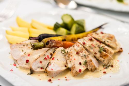 a white plate of food with meat and vegetables at Acanthus blue in Corfu Town