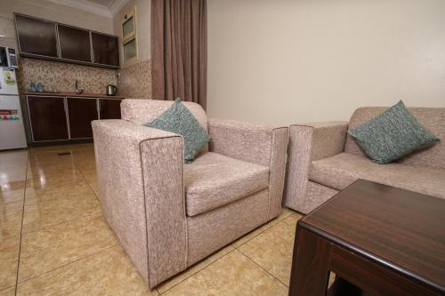 a living room with two couches and a kitchen at Lina Park 2 in Dammam