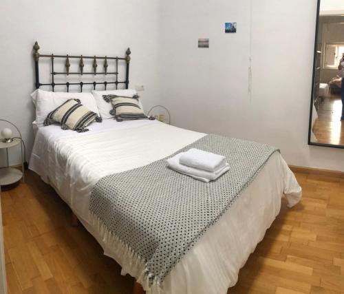 a bedroom with a large bed with two towels on it at Casa de los Chilenos in Oviedo