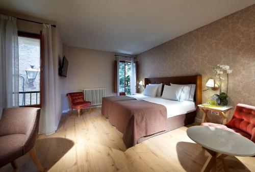 a bedroom with a bed and a table and a chair at Exe Casa de Los Linajes in Segovia