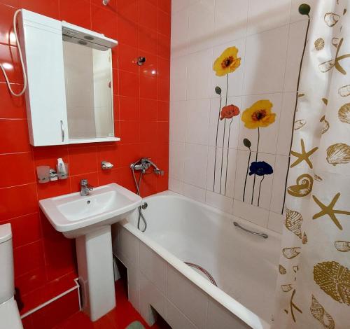 bagno con lavandino, vasca e specchio di Elite Apartment in street Orozbekova 2 a Bishkek