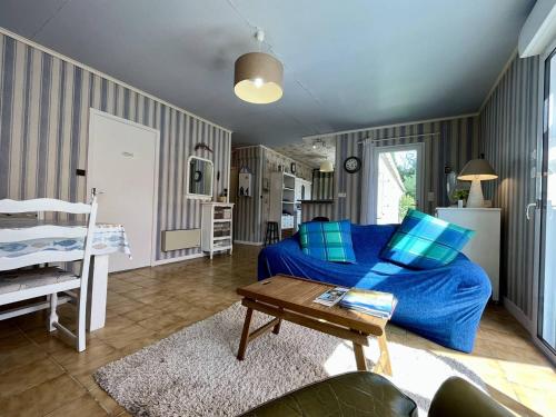 - un salon avec un lit bleu et une table dans l'établissement Maison calme à Saint-Pierre d'Oléron, proche centre et commerces, 5 km de la mer, 5 couchages, terrasses - FR-1-246A-252, à Saint-Pierre-dʼOléron