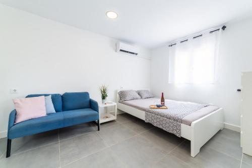 ein Schlafzimmer mit einem Bett und einem blauen Stuhl in der Unterkunft Casa Maruchi - Studio 2 in Almería