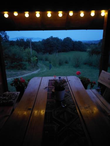 a wooden table in a porch with lights on it at Kuća za odmor Filipović in Gornji Milanovac