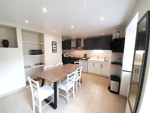 a kitchen with a table and some white chairs at Gite Porte de Champagne Levroux in Levroux