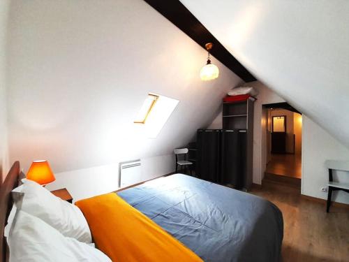 Gite Porte de Champagne Levroux في Levroux: غرفة نوم بسرير في العلية