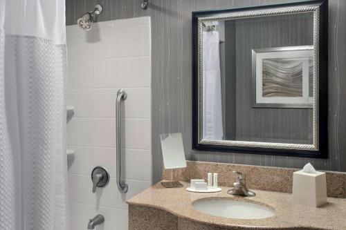 uma casa de banho com um lavatório, um espelho e um chuveiro em Courtyard by Marriott Paramus em Paramus