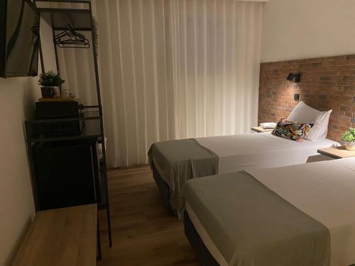 a hotel room with two beds and a television at Hotel Portucalense in Porto