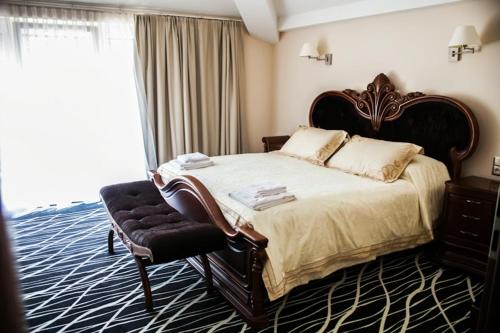 a bedroom with a large bed and a chair at Hotel Binkowski in Kielce