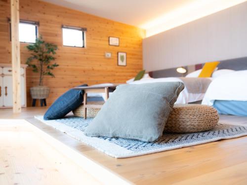 a room with a bed with pillows on a rug at GLAMP ELEMENT(グランエレメント） in Maibara