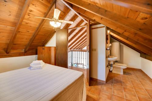 - une chambre avec un lit dans une pièce dotée de plafonds en bois dans l'établissement Casa rural entre Ojén y Marbella, à Ojén