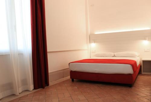 a bedroom with a bed with red and white sheets at Primavilla Relais in Gaeta