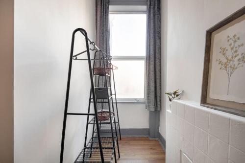 a ladder in a room with a window at 2A - Bright & Airy 2 Bed Flat - 20 Mins to Central in London