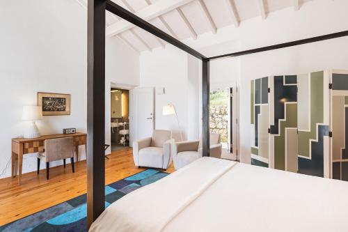 a bedroom with a bed and a desk at Imani Country House in Évora