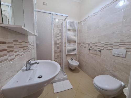 a white bathroom with a sink and a toilet at B&B Villa Mery in Mileto