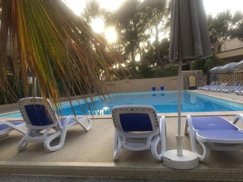 two blue and white chairs and a swimming pool at Les Appartements de La Marina in Sanary-sur-Mer